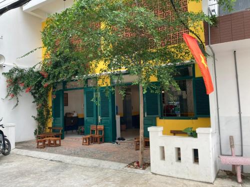 a building with green and yellow doors and a tree at B475house in Nha Trang