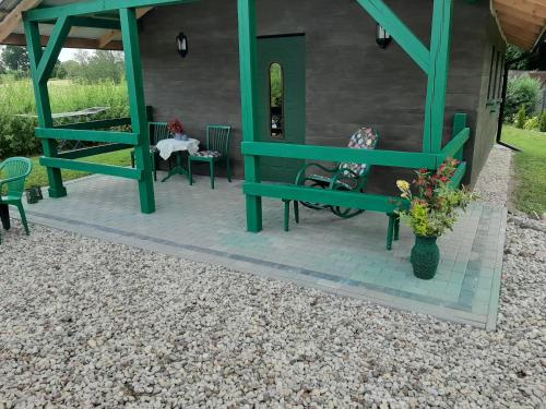 a patio with a green bench and a table and chairs at Odsapka u Agi in Wydminy