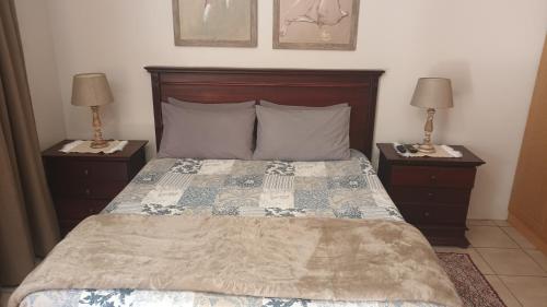 um quarto com uma cama grande e 2 mesas de cabeceira em Lushof Guesthouse em Witbank