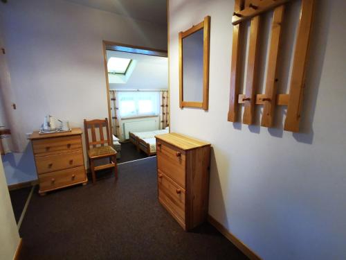 a room with a desk and a dresser and a mirror at Willa Hamernik AGROTURYSTYKA in Tylicz