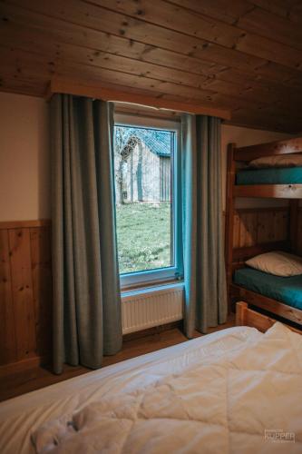 a bedroom with a bed and a window at Le Tétras Lyre - 28 pers - Malmedy in Malmedy