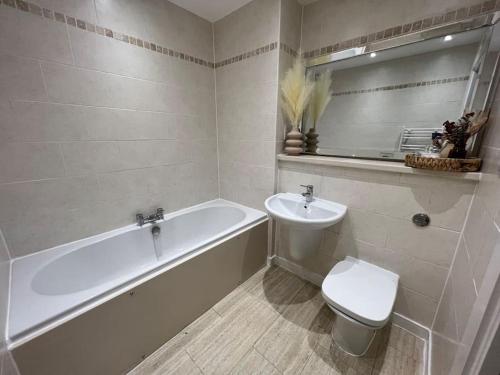 y baño con bañera, aseo y lavamanos. en Apartment in Birkdale - 2 bedrooms en Southport