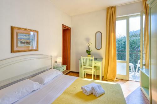 een slaapkamer met een bed met twee handdoeken erop bij Hotel Silvana Garnì in Limone sul Garda