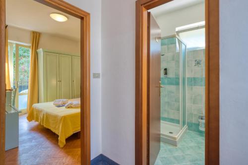 een slaapkamer met een bed en een glazen douche bij Hotel Silvana Garnì in Limone sul Garda