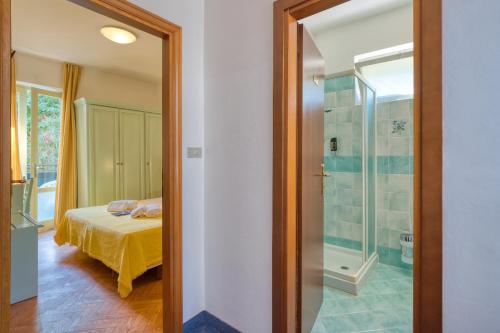 a bedroom with a bed and a glass shower at Hotel Silvana Garn&igrave; in Limone sul Garda