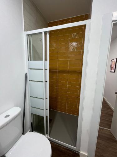 a bathroom with a toilet and a glass shower at Pérola do Ar - Estúdio no coração de Setúbal in Setúbal