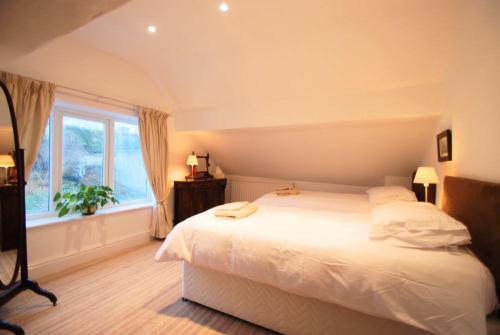 um quarto com uma grande cama branca e uma janela em Estuary View Apartment em Deganwy