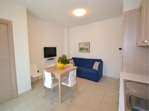 a living room with a table and a blue couch at Modern and bright apartment - Beahost Rentals in Rosolina Mare