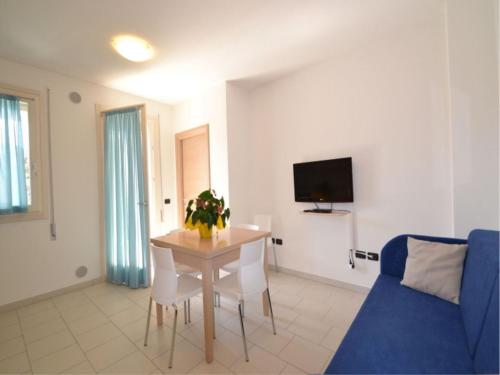 a living room with a table and a blue couch at Modern and bright apartment - Beahost Rentals in Rosolina Mare
