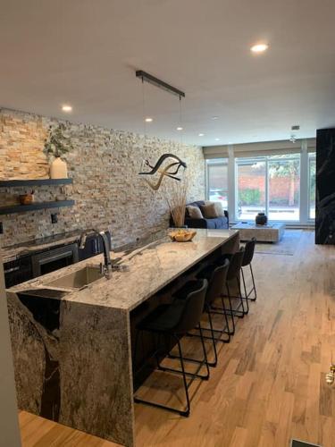a kitchen with a large counter with a sink and chairs at Most Luxurious1Br in town And steps to the Gondola in Telluride