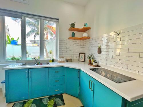 a kitchen with blue cabinets and a sink at The Beachhouse Villa- 4 bedrooms Villa- 5' to Bai Sau Beach in Xã Thang Tam
