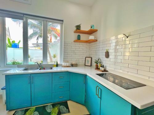 Una cocina con gabinetes azules y un fregadero. en The Beachhouse Villa- Biệt Thự 4 Phòng Bãi Sau- 4 bedrooms Villa- 5' to Bai Sau Beach, en Xã Thang Tam