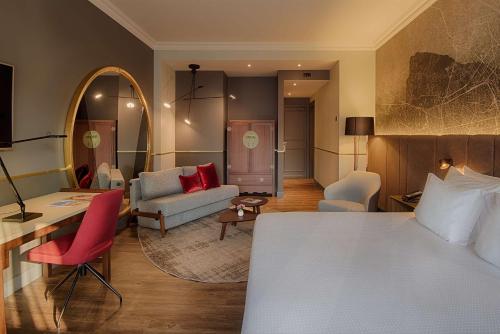 ミラノにあるNH コレクション ポルタ ヌオーヴァのベッドとリビングルームが備わるホテルルームです。