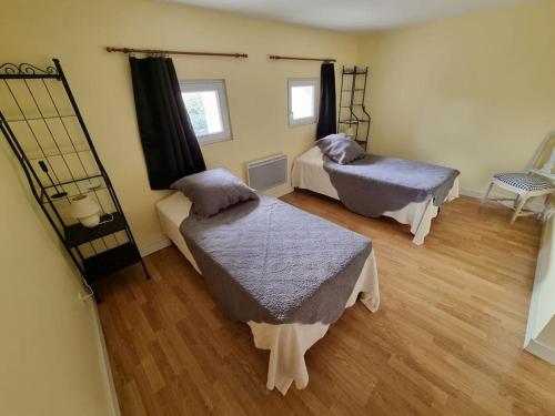 une chambre avec deux lits et une chaise dedans dans l'établissement Merlinite - 4 couchages, à Archigny