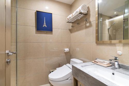 a bathroom with a toilet and a sink and a mirror at Cloud Land Apartment 翡翠华庭 in Guangzhou