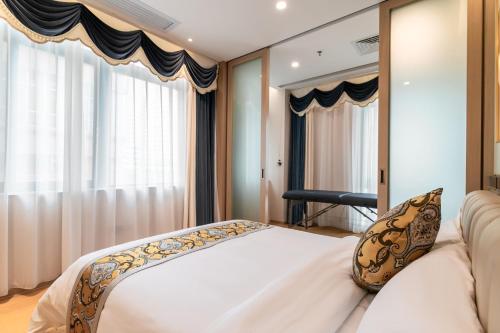 1 dormitorio con cama blanca y ventana en Cloud Land Apartment 翡翠华庭 en Guangzhou