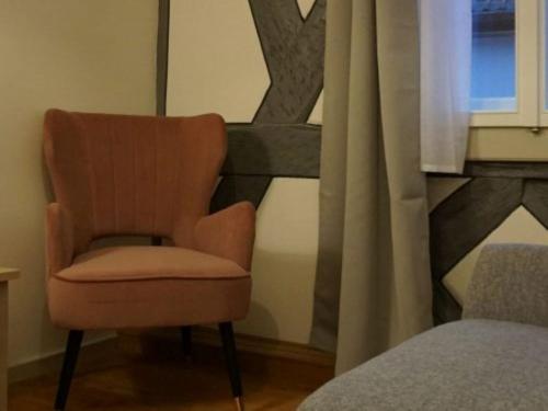 uma cadeira sentada num quarto ao lado de uma janela em Gasthof Weißes Ross em Iphofen