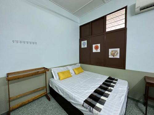 um quarto com uma cama e uma cabeceira em madeira em Ipoh Canning Garden Simple House 4R3B 12pax SY19 em Ipoh