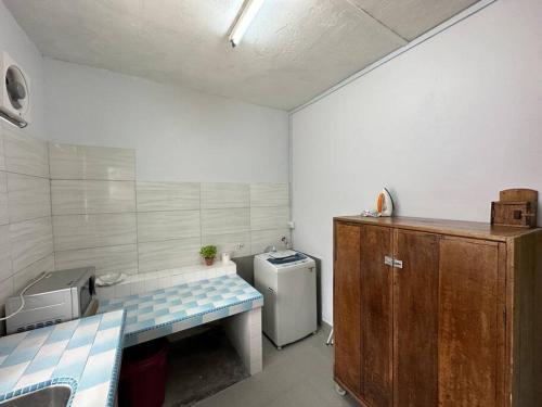uma pequena casa de banho com um lavatório e um frigorífico em Ipoh Canning Garden Simple House 4R3B 12pax SY19 em Ipoh