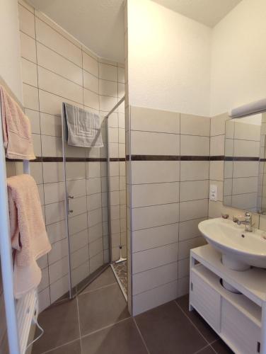 une salle de bain blanche avec un lavabo et une douche dans l'établissement Chambres d'Hôtes La Courlande, à Saint-Haon-le-Vieux