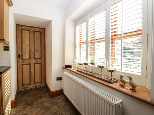 a kitchen with a window ledge with candles on it at The Anvil in Broughton in Furness