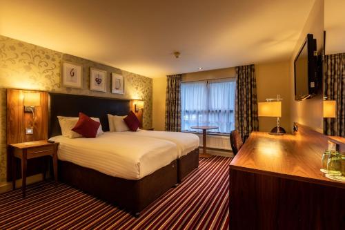 a hotel room with a bed and a desk at Gloucester Robinswood Hotel, BW Signature Collection in Gloucester