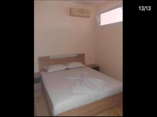 een slaapkamer met een bed met witte lakens en een raam bij Golden Sea View 2 in Pomorie