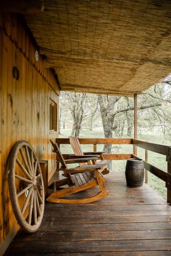 two chairs sitting on a porch of a cabin at Le Ranch Amadeus in Saint-Paul-en-Born