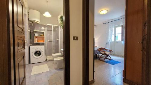 a bathroom with a washer and dryer in a room at Casa Antonietta in Orosei