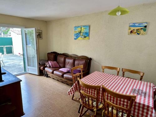 un salon avec une table et un canapé dans l'établissement Maison 3 pièces proche mer à Argelès-sur-Mer - 5 couchages, terrasse, parking, mén. inclus - FR-1-225-2, à Argelès-sur-Mer
