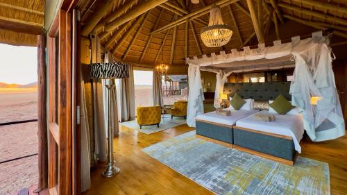 ein Schlafzimmer mit einem großen Bett in einem Zimmer in der Unterkunft Namib Outpost in Sesriem