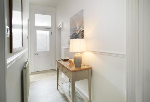 a room with a table with a lamp on it at Ariel in Marcross