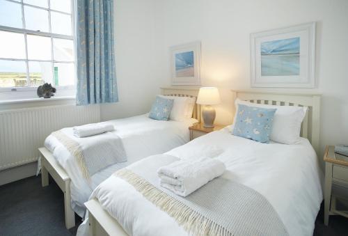 two twin beds in a room with a window at Ariel in Marcross