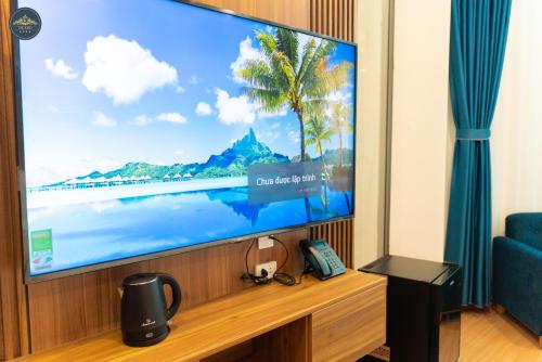 a large flat screen tv sitting on a stand in a room at The King Hotel - Condotel Thai Nguyen in Thái Nguyên