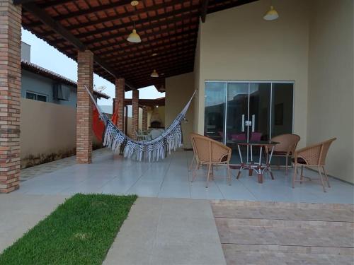 a patio with a hammock and a table and chairs at Casa Praia Luís Correia in Luis Correia
