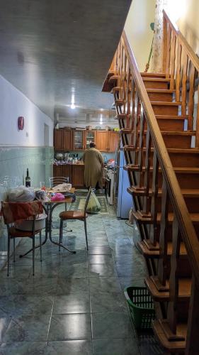 a kitchen with a staircase and a table in a room at Cosy Guesthouse in Tskaltubo
