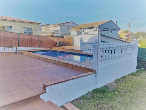 un patio trasero con piscina y valla en CASA INDEPENDIENTE CON PISCINA A 2 KM. DE LA PLAYA, en Segur de Calafell