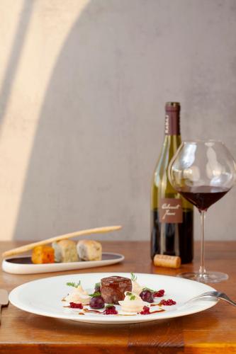 a table with a plate of food and a bottle of wine at KABAJ Wine & Dine in Dobrovo