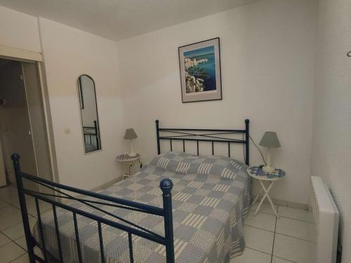 une chambre avec un lit et un miroir au mur dans l'établissement T2 4 pers Le Barcarès RDC Piscine Parking Animaux - FR-1-195-68, au Barcarès