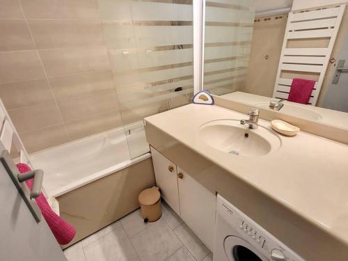 une salle de bain avec un lavabo, une baignoire et un miroir dans l'établissement T2 cosy avec piscine, tennis, parking - 200m des plages - FR-1-316-245, à Six-Fours-les-Plages