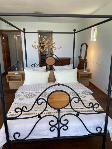 a bedroom with a black canopy bed with white pillows at Top floor studio -Villa Ibiza in Trou dʼ Eau Douce