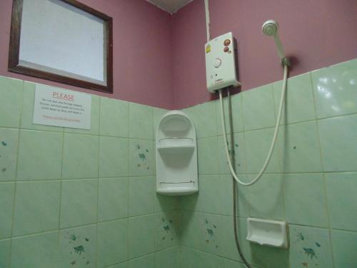ein Bad mit einem Urinal und einem Fenster in der Unterkunft Moonhut Bungalows in Mae Nam
