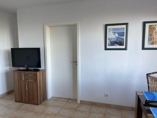 sala de estar con TV en un armario de madera en Haus-am-Waldbad-Whg-12-7 en Cuxhaven