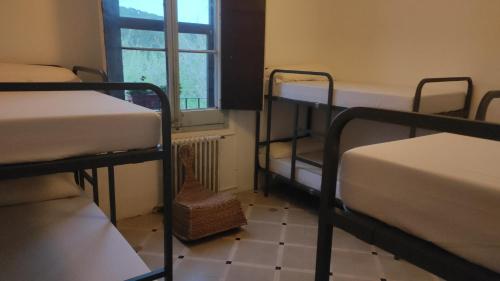 a room with three bunk beds and a window at Can Rabassa in Vallromanes