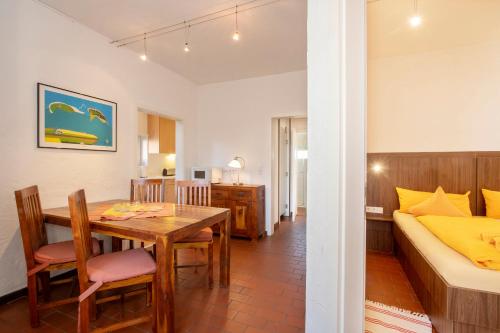 a room with a dining table and a bedroom at Lütje Hus in Langeoog