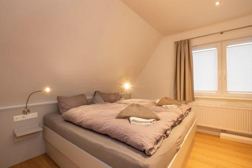 a bed in a room with a large window at Ferienwohnung '2' im OTTEN in Langeoog