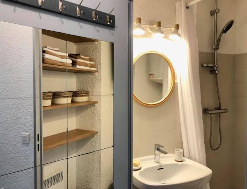 La salle de bains est pourvue d'un lavabo et d'un miroir. dans l'établissement Appartement calme et chaleureux, à Six-Fours-les-Plages