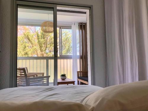 - une chambre avec un lit et un balcon avec une fenêtre dans l'établissement Appartement calme et chaleureux, à Six-Fours-les-Plages