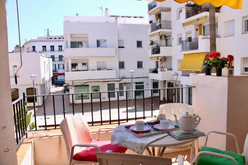 Ein Tisch und Stühle auf einem Balkon mit Blick auf eine Stadt in der Unterkunft Oasis Sinia by Hello Homes Sitges in Sitges