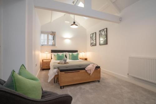 a bedroom with a bed with green pillows and a chair at Contemporary Home by LetMeStay in Carnforth